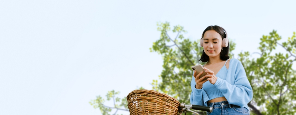 young woman on bicycle checking mobile