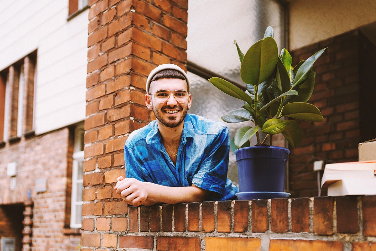 A man leaning on a balcony and smiling