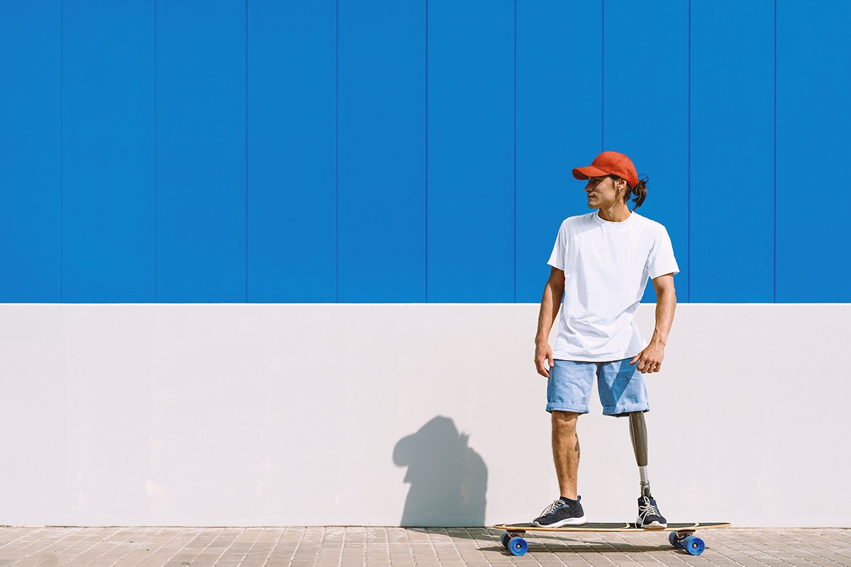 A man on a skateboard in front of a blue wall