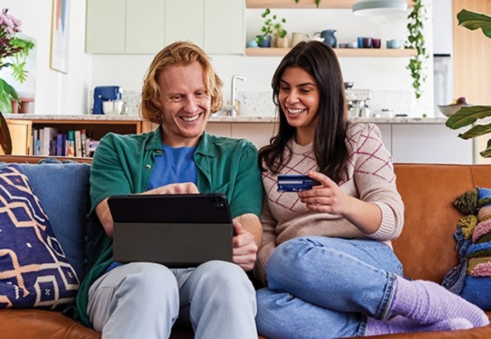 couple looking tab and ANZ card